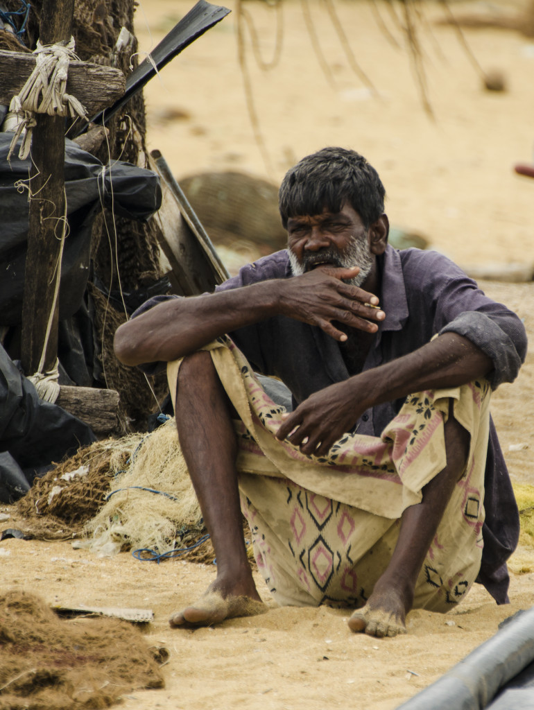Sinhalese fisherman relaxing after hard work in the catamaran.